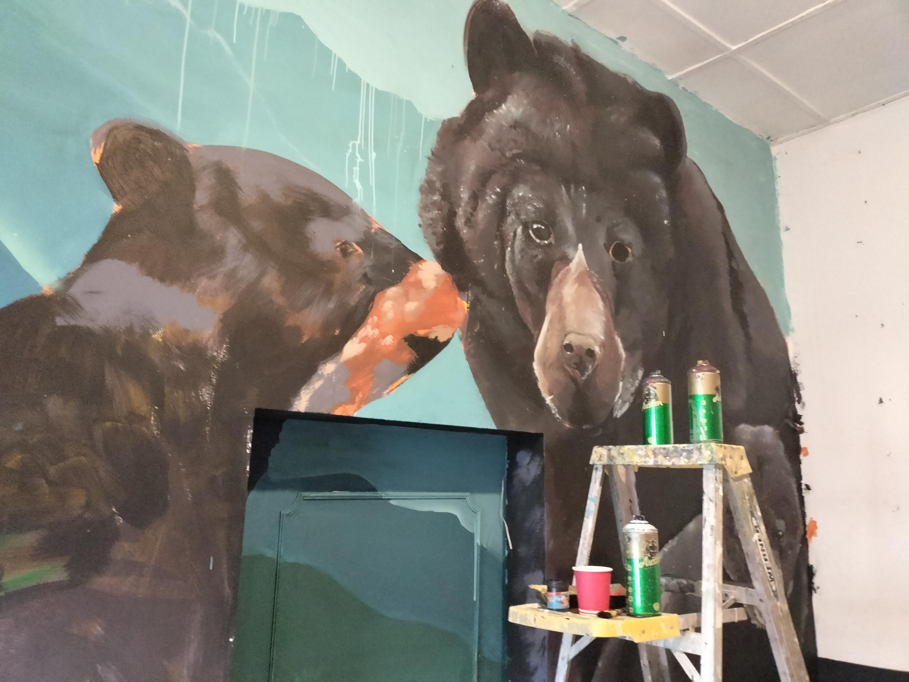 Artistas pintando mural en proceso