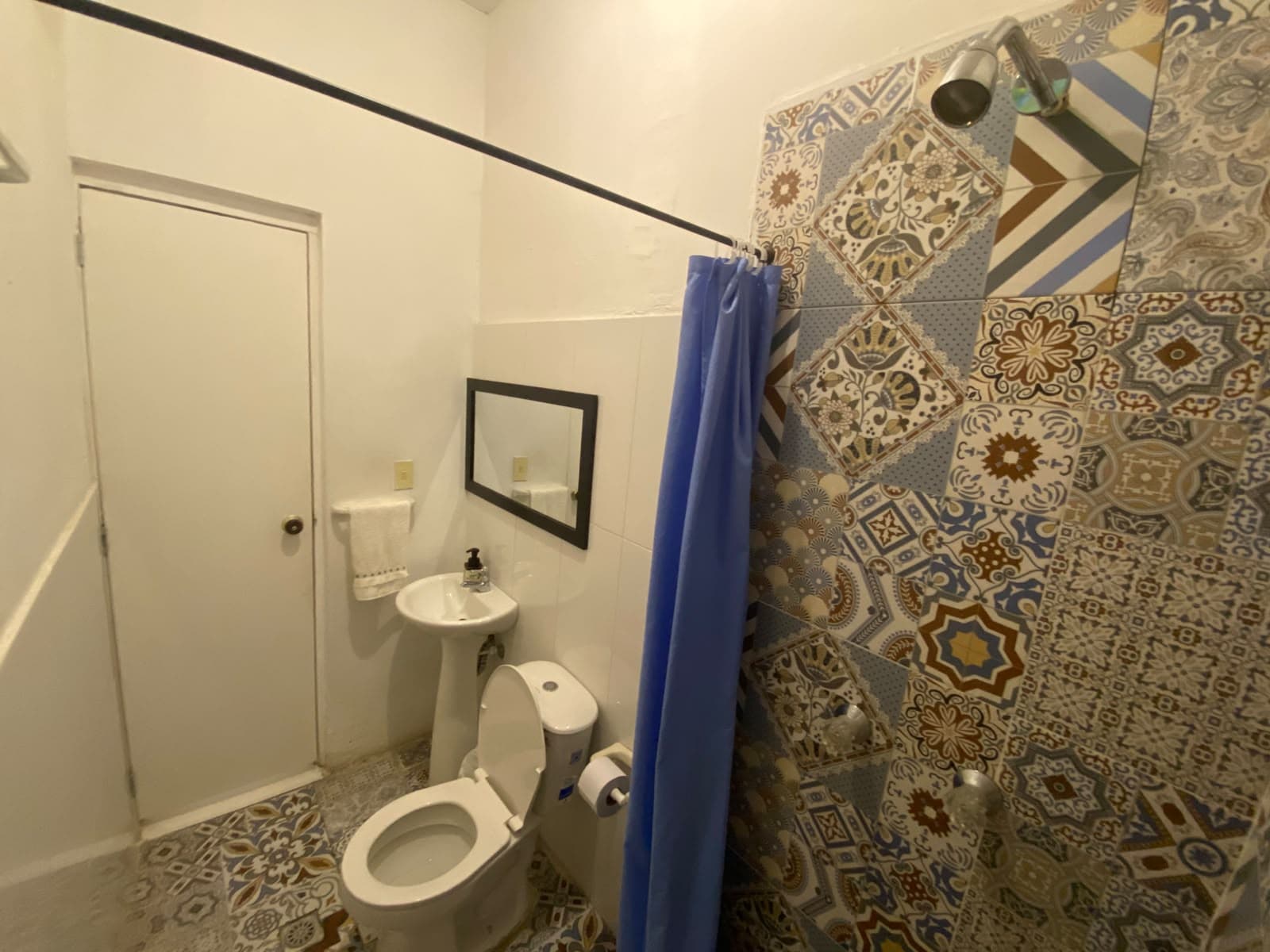 Baño con ducha cerámica artesanal en suite Lienzo Hostel